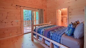 Une chambre dans un chalet en bois, avec un lit, un canapé et un balcon.