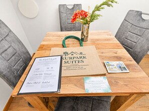 A wooden table with a menu, a guest card, and a brochure.