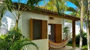 A small, single-story building with a porch and a hammock.