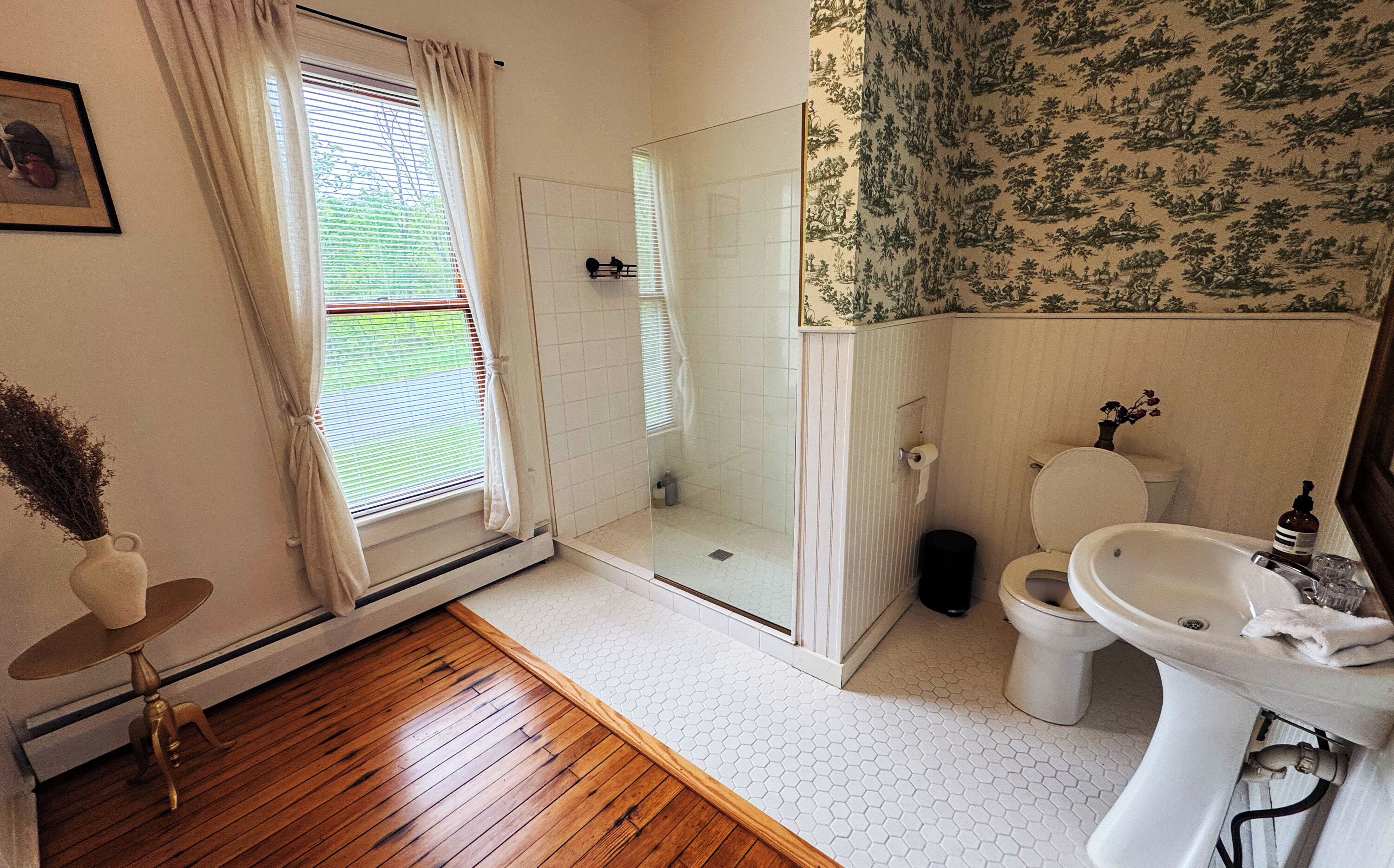 Un baño con ducha, inodoro y lavabo.