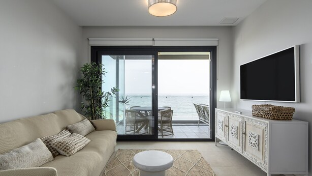 A modern living room with a sofa, a coffee table, a cabinet, and a TV.