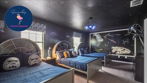 A bedroom with two bunk beds, each with a circular headboard and a Star Wars-themed pillow.