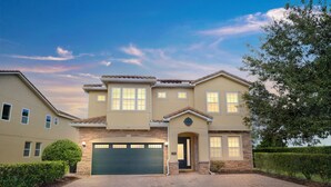 A two-story house with a garage, a front door, and a small porch. - 25% Off 10BR Encore Pool Villa Near DIsney (Kissimmee)