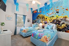 A room with two beds, a ceiling fan, a window with curtains, and a mural of an underwater scene. - Caribbean-Inspired Bahama Bay Resort Condo | 3BR Near Disney with Pools & Beach (Davenport)