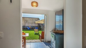 A room with a view of a backyard, a dining area, and a cabinet with drawers.
