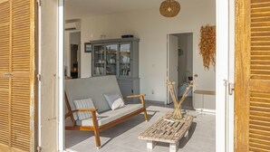An open door leading to a living area with a sofa, a wooden coffee table, and a cabinet with glass doors.