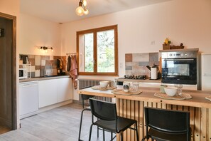 A kitchen with a wooden countertop, a built-in oven, and a window.