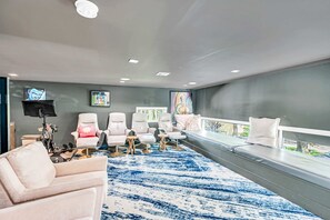 A modern room with a large window, a blue patterned rug, and multiple seating areas. - Miami Stunning Waterfront Villa Escape (North Bay Village)
