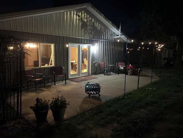 A building with a patio area featuring outdoor seating and potted plants.