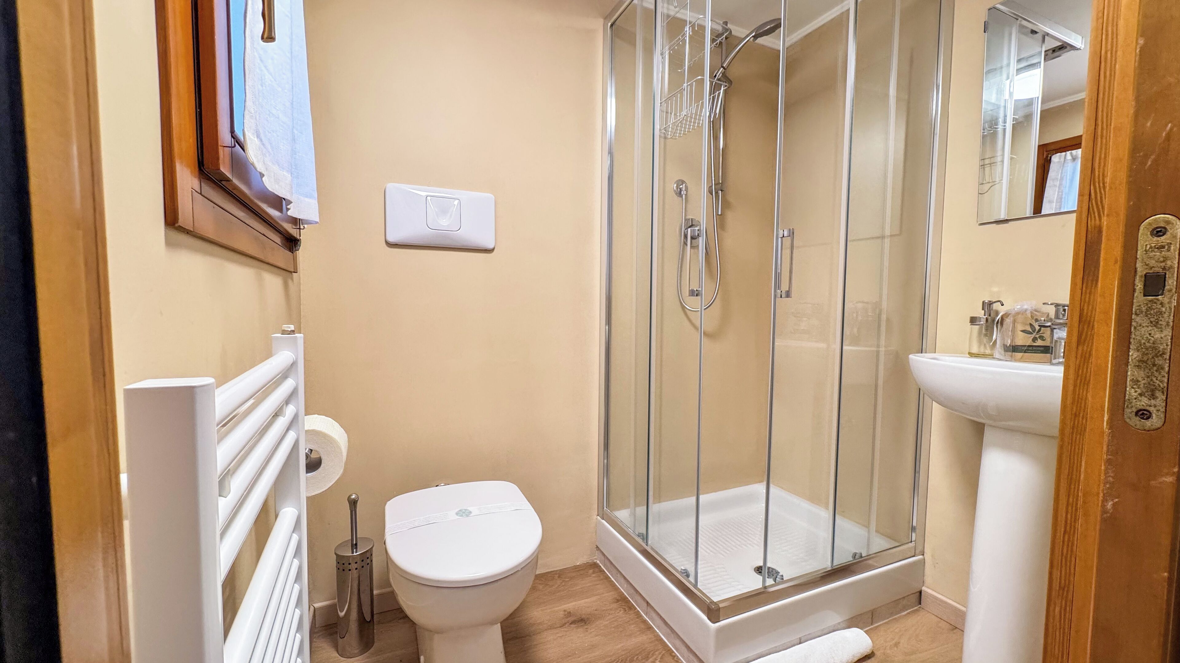 Une salle de bain avec une douche à parois de verre, des toilettes, un lavabo et un miroir.