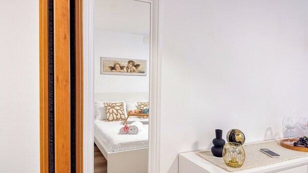 Een hotelkamer met een bed, een nachtkastje met een vaas, een wereldbol en een afstandsbediening.