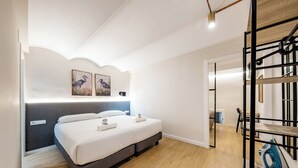 A modern bedroom with a bed, bedside tables, and a headboard. - Recently refurbished one bedroom apartment (Barcelona)