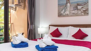 Quarto de hotel com cama, almofadas e um quadro na parede.