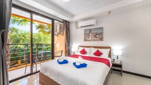 Quarto de hotel com uma cama grande, varanda com vista para palmeiras e ar condicionado na parede.