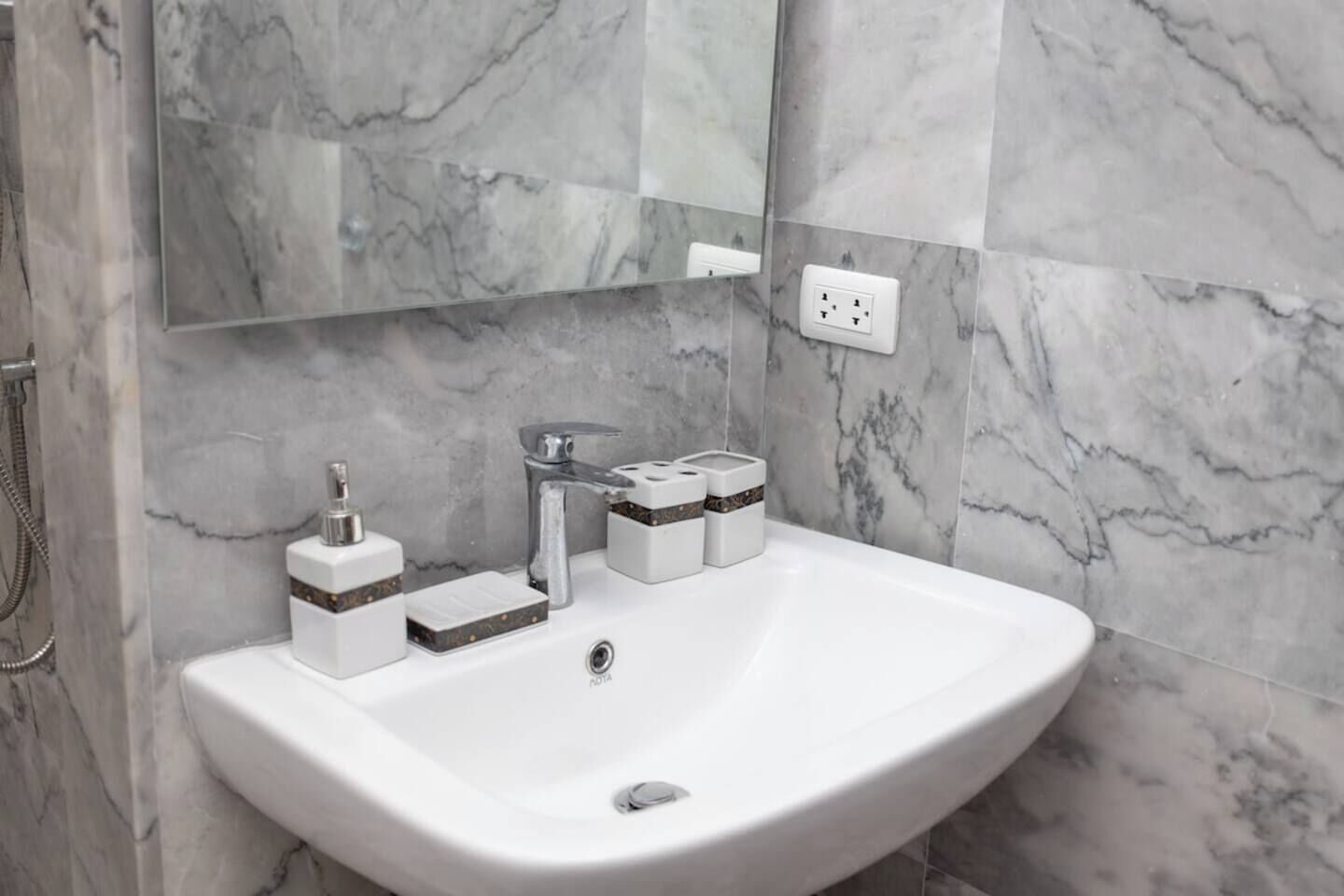 A bathroom with a white sink, a mirror, and a shower.