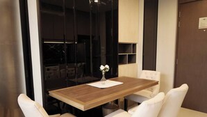 Un'area pranzo moderna con tavolo in legno e sedie imbottite bianche.