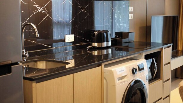 Una cucina moderna con zoccolo in marmo, elettrodomestici in acciaio inossidabile e mobili in legno.
