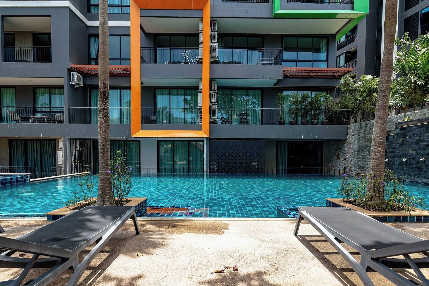 Un hôtel à plusieurs étages doté d’une piscine, d’un espace extérieur aménagé et d’une architecture moderne.