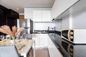 A modern kitchen with white cabinets, a black countertop, and a built-in oven.