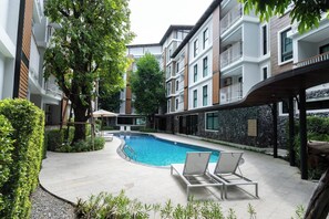 A modern residential building with a swimming pool, lounge chairs, and a covered patio area. - Suite Lumaire 1br | Pool view | the title v rawai (Rawai)