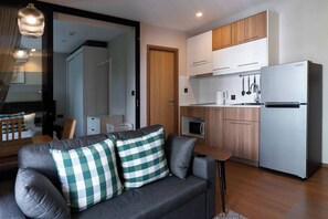A modern kitchen with white cabinets, a stainless steel refrigerator, and a microwave. - Suite Lumaire 1br | Pool view | the title v rawai (Rawai)