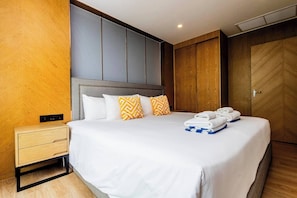 A hotel room with a bed, bedside tables, a wardrobe, and a power outlet.