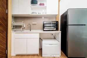 Una cocina con microondas Bosch, lavavajillas Bosch y refrigerador de acero inoxidable.