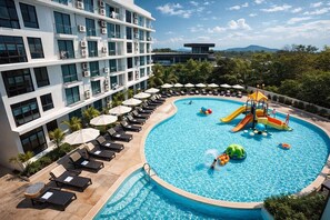 Un hotel con piscina, tumbonas y zona de juegos acuáticos.
