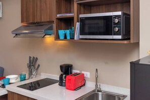 Eine Küche mit Mikrowelle, Toaster, Kaffeemaschine und Besteck auf der Arbeitsfläche.