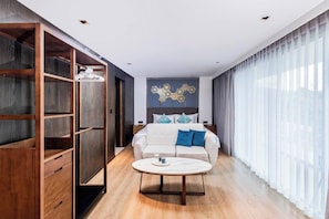 Une chambre d’hôtel moderne équipée d’un lit, d’un canapé, d’une table basse et d’une armoire.