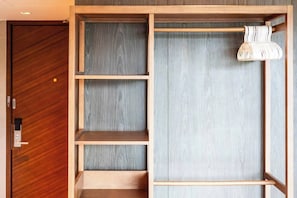 Une pièce avec une porte en bois, une armoire dotée de plusieurs étagères et un luminaire suspendu.
