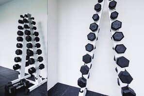 A wall-mounted dumbbell rack with multiple sets of hexagonal dumbbells. - Suite Verda 1br | Garden view | fantasea kamala (Tambon Kammala)