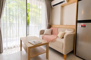 Una sala moderna con un sofá, una mesa de centro y un refrigerador.