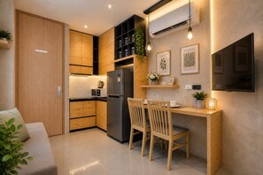 A modern kitchen with wooden cabinets, a built-in fridge, and a dining area with chairs and a table.