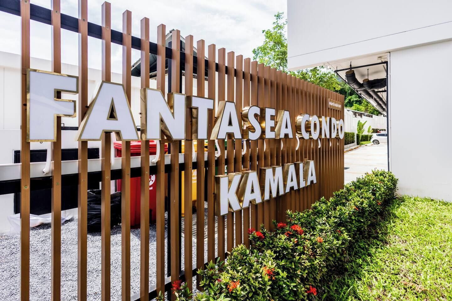 Een bord voor FANTASEA CONDOMINIUM KAMALA met een modern ontwerp en uitzicht op de parkeerplaats.