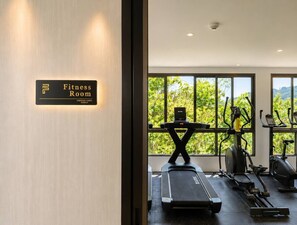 Een fitnessruimte met sportapparatuur en een bordje dat de functie aangeeft.