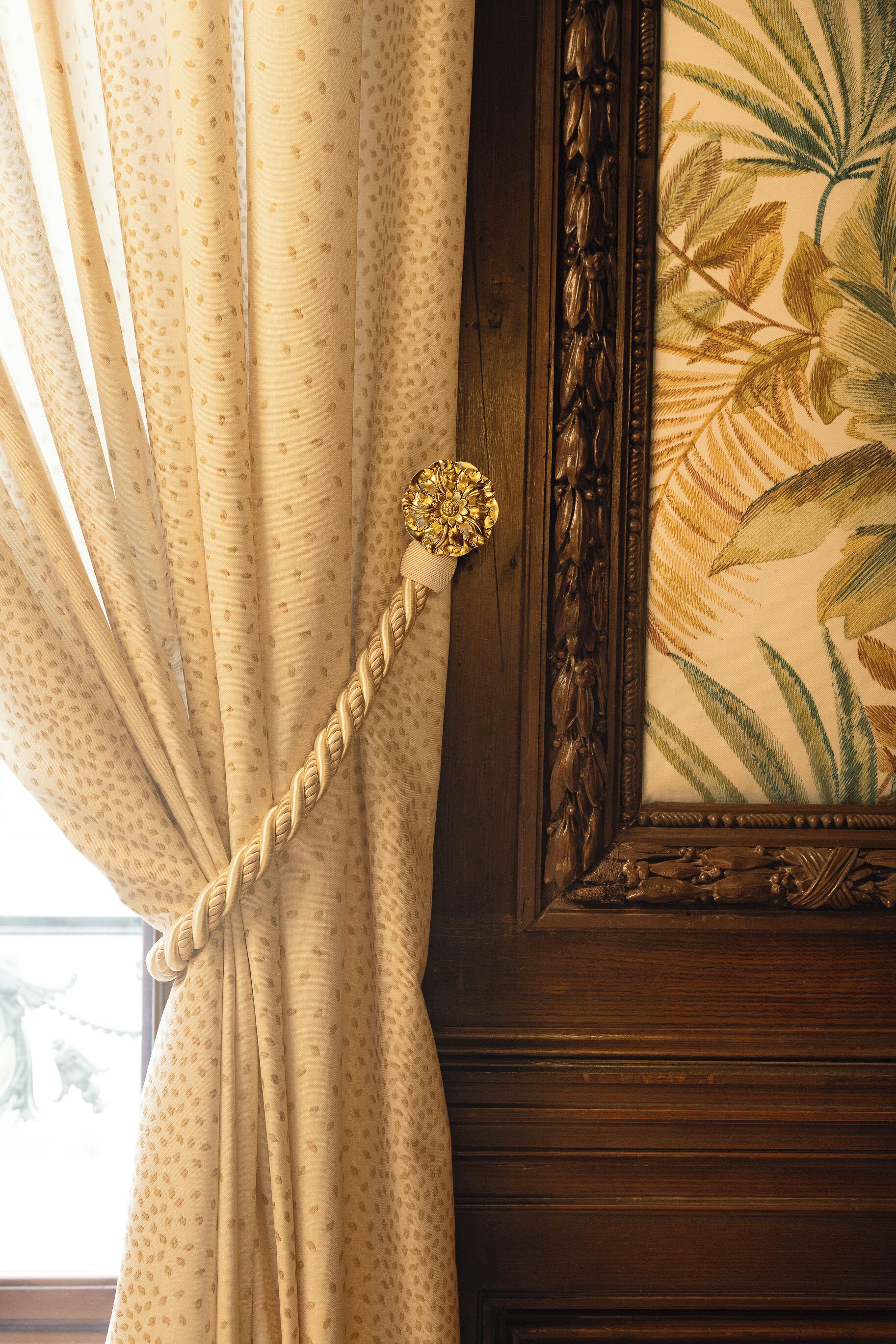 A curtain with a polka dot pattern and a decorative knot.