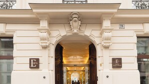 A grand entrance with a large archway, columns, and a sign indicating the hotel name and year established. - EST Hotel Palais Chotek NEW OPENING (Vienna)