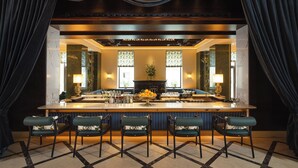 A bar area with a marble countertop, bar stools, and a large mirror. - EST Hotel Palais Chotek NEW OPENING (Vienna)