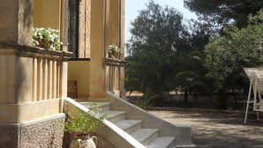 A building with a stone staircase leading to a door with a wrought iron gate.