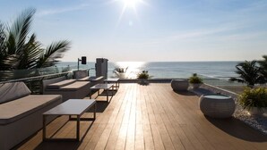 A wooden deck with outdoor seating and potted plants, overlooking a body of water. - Ace of Hua Hin Resort - Ace Deluxe Pool Access (Cha-am)