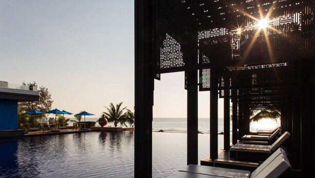 An infinity pool with lounge chairs and umbrellas, overlooking the sea. - Ace of Hua Hin Resort - Ace Deluxe Pool Access (Cha-am)