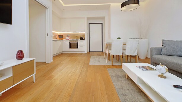 Un appartement moderne comprenant une cuisine, un coin repas et un salon.