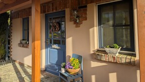 A building with a blue door, a brick wall, and a window with a plant. - Family-Friendly Holiday Home 'Märchengarten Fischer Un Sin Fru' (Putbus)