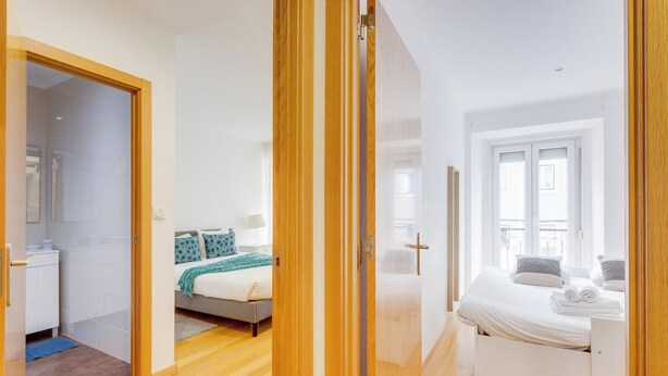 A modern bedroom with a bed, bedside tables, and a window. - Nigrum Apartment, Santos, Lisbon (Lisboa)