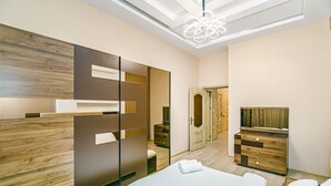 A modern bedroom with a bed, a dresser, a mirror, and a wardrobe. - Квартира супер отремонтирована. Комбинированная система. (Bakı)