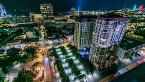 A high-rise building with a central courtyard, surrounded by other buildings and a busy street. - Квартира супер отремонтирована. Комбинированная система. (Bakı)