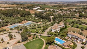 An aerial view of a residential area with a large swimming pool, tennis courts, and a golf course. - 2 bedroom nice home in Arcos de la Frontera (Arcos de la Frontera)
