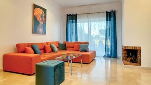 A living room with a sectional sofa, a glass coffee table, and a fireplace. - 2 bedroom nice home in Arcos de la Frontera (Arcos de la Frontera)