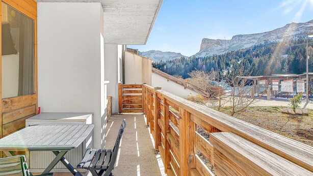 A balcony with a wooden railing, a table, and a bench. - 'Superdevoluy' Apartment with Mountain View and Balcony (Dévoluy)